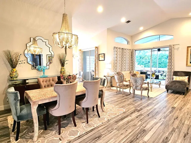 a view of a dining room with furniture a chandelier and wooden floor