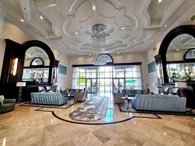 a living room with furniture a chandelier and a large window