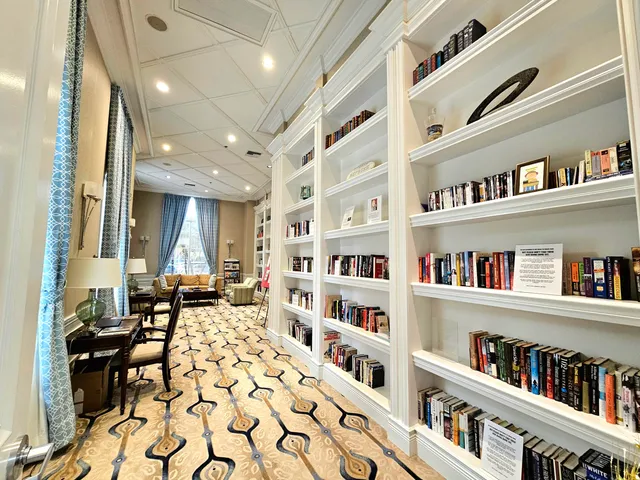 a living room with lots of books and a book shelf