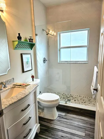 a bathroom with a granite countertop sink toilet and a mirror