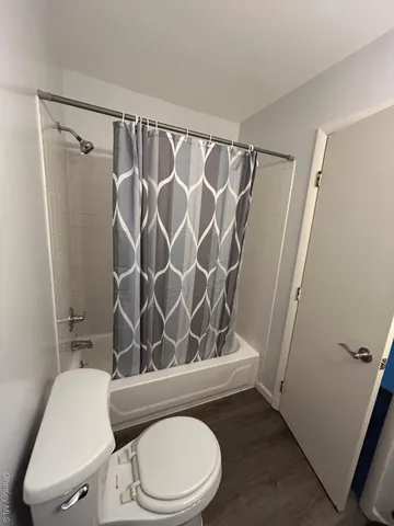 a bathroom with a toilet and a shower curtain