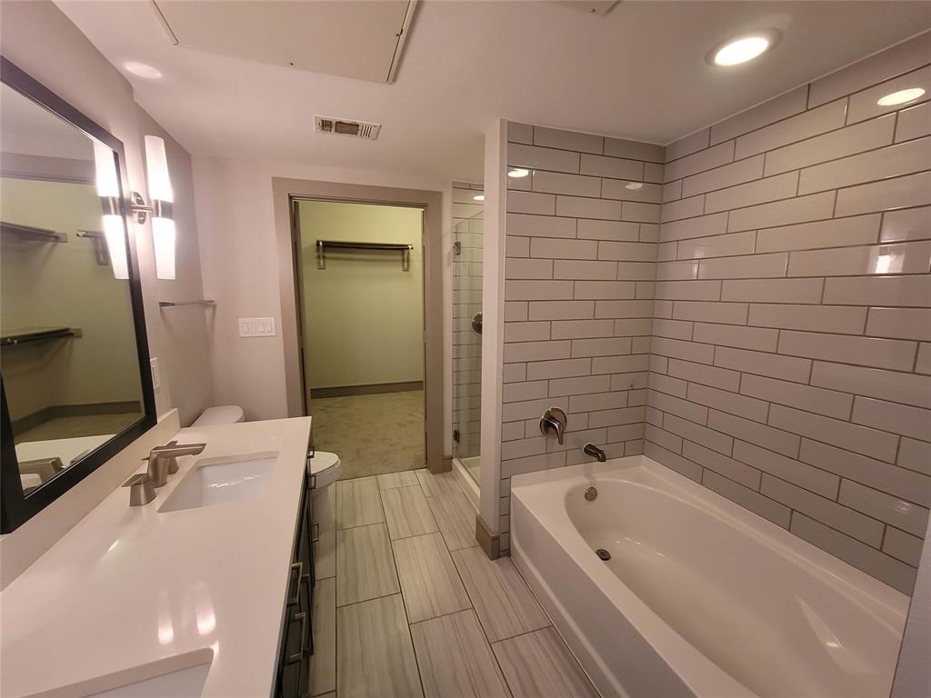 a bathroom with a tub a sink a mirror and a shower