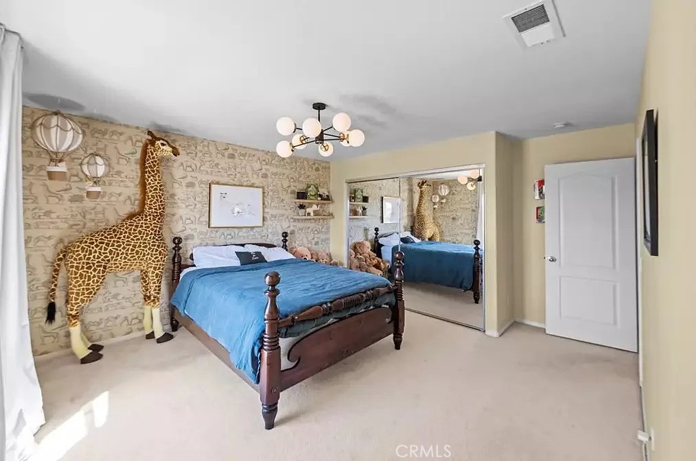 44840 Tudal Street Temecula, CA 92592 - Photo 18 of 35 a spacious bedroom with a bed and a chandelier