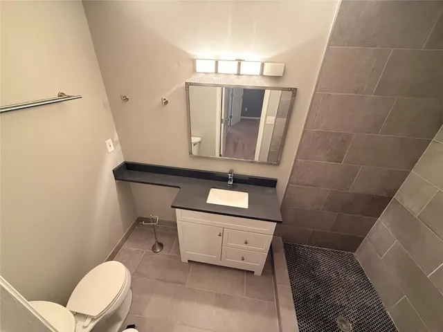 a bathroom with a toilet a sink and mirror