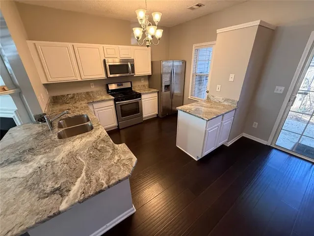 a kitchen with granite countertop a stove and a refrigerator