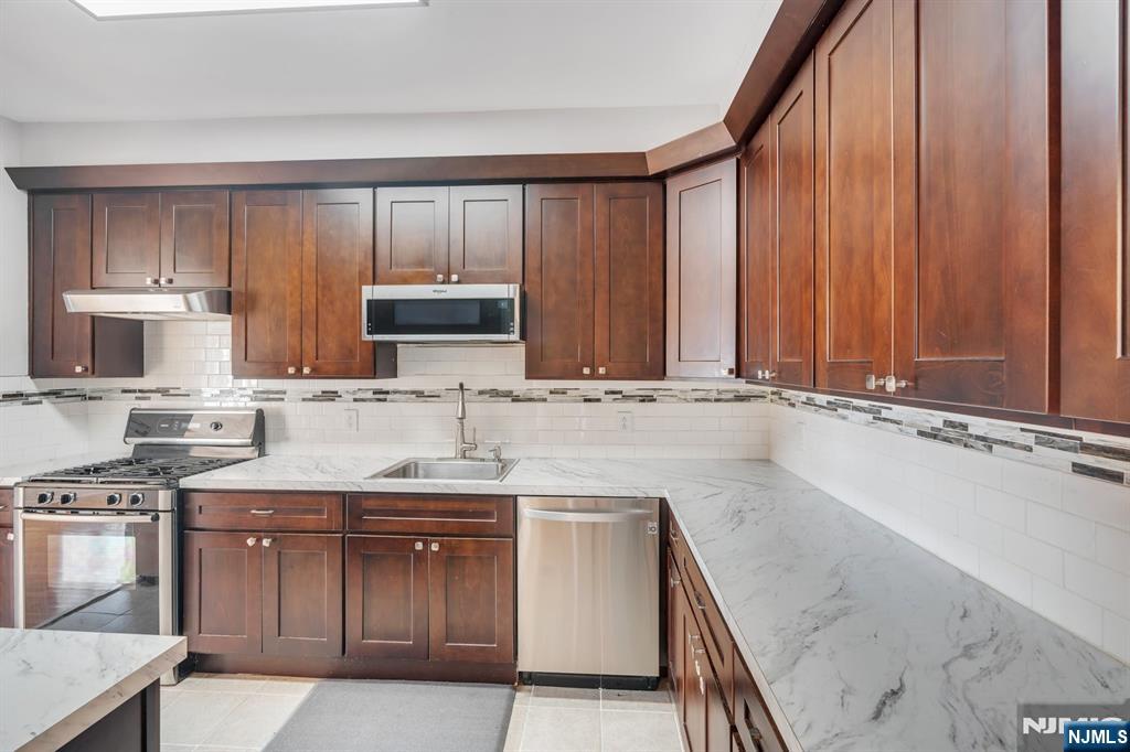 66 Bergen Ridge Road, Unit 1 North Bergen, NJ 07047 - Photo 12 of 26 a kitchen with stainless steel appliances granite countertop a sink stove and microwave