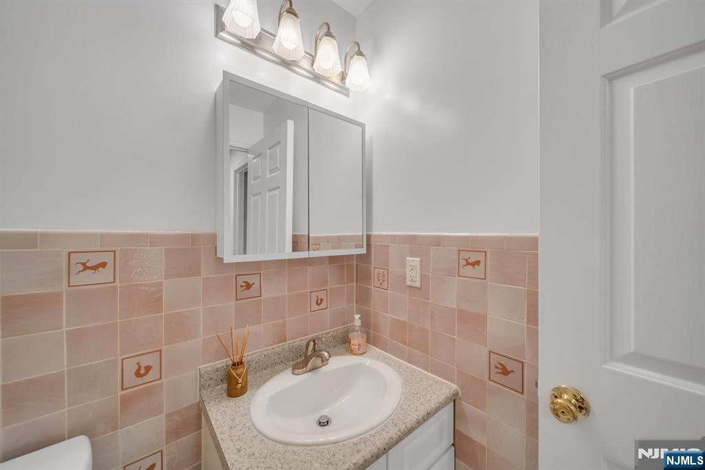 66 Bergen Ridge Road, Unit 1 North Bergen, NJ 07047 - Photo 22 of 26 a bathroom with a sink a mirror and shower