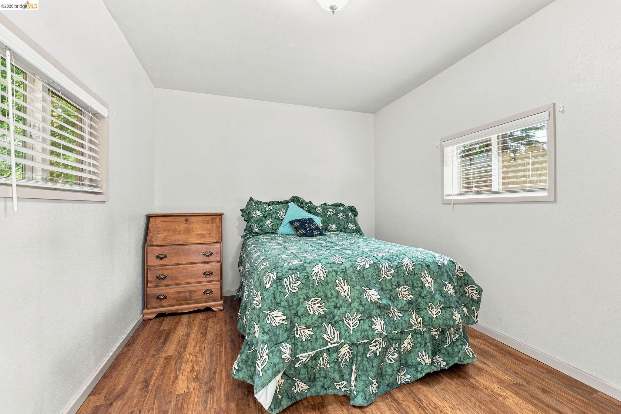 26457 Crystal Road Long Barn, CA 95335 - Photo 22 of 39 Room with wood-finish flooring, white walls, and two windows with blinds