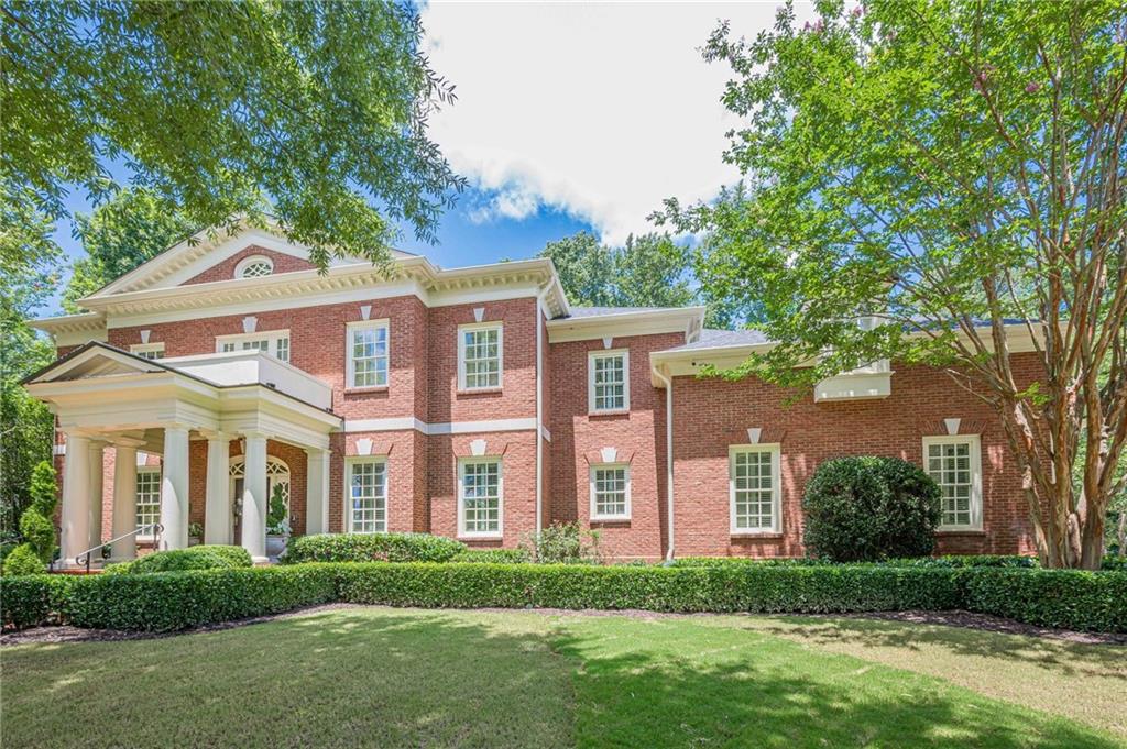 front view of a brick house with a yard