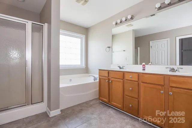 a spacious bathroom with a tub sink shower and mirror
