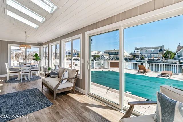 a living room with furniture floor to ceiling window and wooden floor