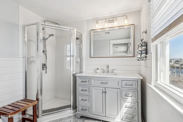 a bathroom with a granite countertop sink a mirror a vanity and shower