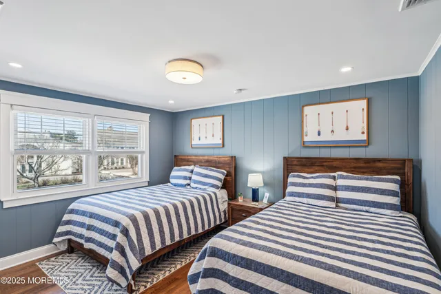 a bedroom with two beds and a large window