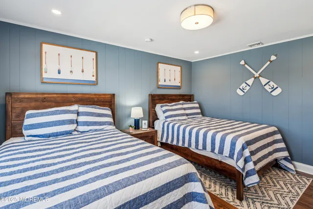 a bedroom with two beds and painting on the wall