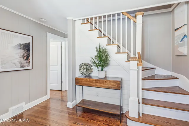 a view of entryway and hall with wooden floor