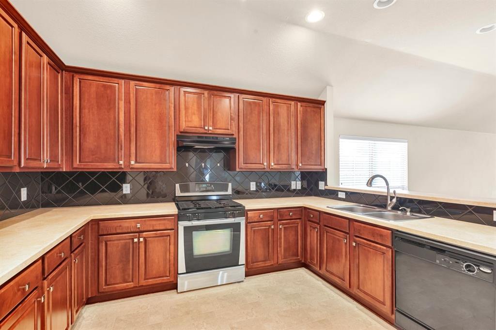 5316 Ridgeson Drive McKinney, TX 75071 - Photo 14 of 33 Kitchen featuring extensive wood cabinetry, light-toned countertops, a stainless steel range, and a black tile backsplash