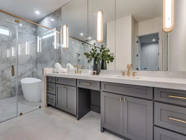 a bathroom with a double vanity sink a large mirror and a bathtub