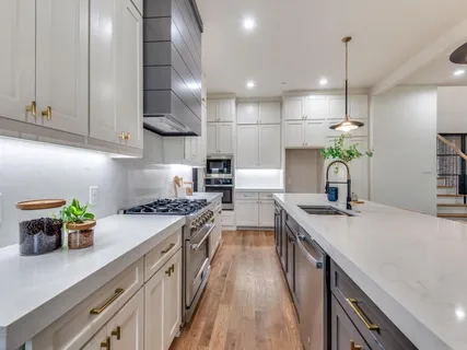 a bathroom with a double vanity sink a large mirror and a bathtub