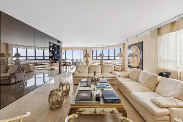 a living room with furniture kitchen view and large windows