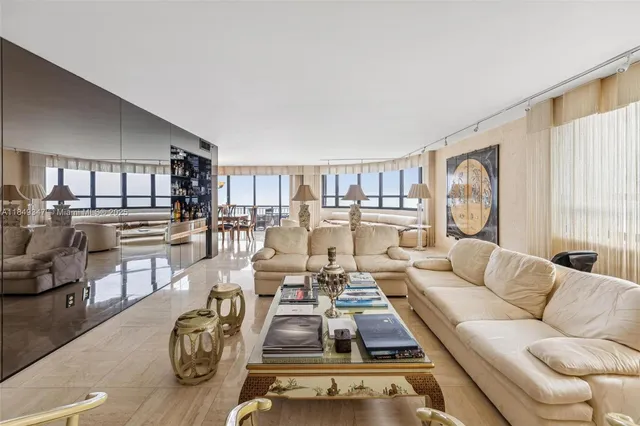 a living room with furniture kitchen view and large windows