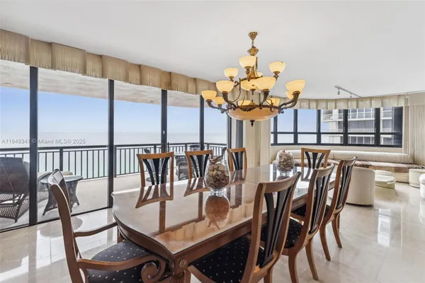 a view of a dining room with furniture a chandelier and wooden floor