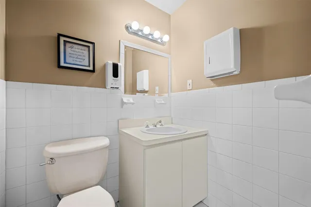 a bathroom with a sink mirror and toilet