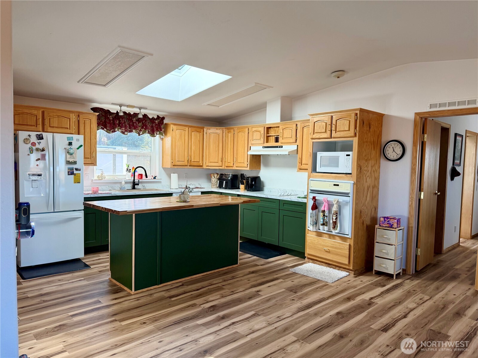 505 Northwest Portland Street Wilbur, WA 99185 - Photo 3 of 40 a kitchen with stainless steel appliances kitchen island granite countertop a refrigerator a sink dishwasher a stove and a dining table with wooden floor