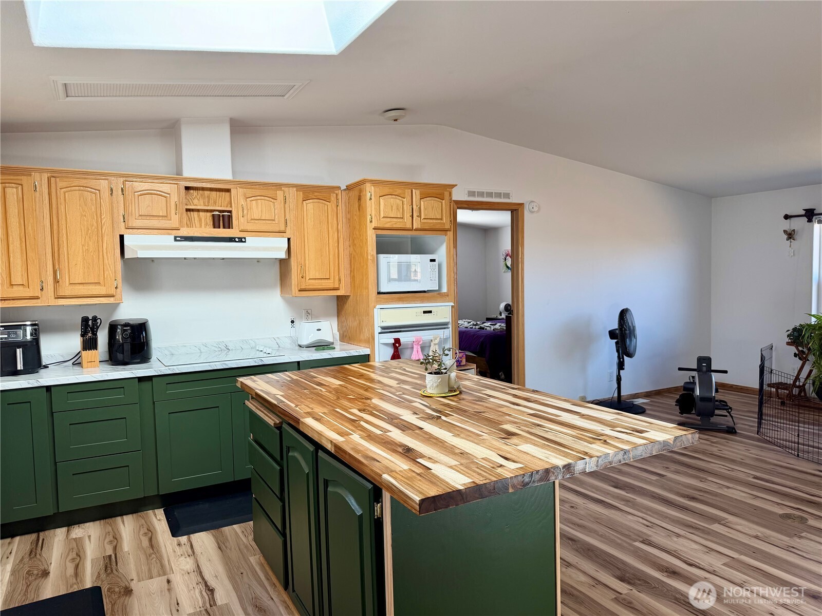 505 Northwest Portland Street Wilbur, WA 99185 - Photo 6 of 40 a kitchen with kitchen island a sink dishwasher a stove and a refrigerator with wooden floor
