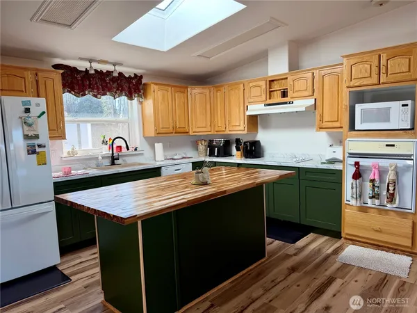 a kitchen with stainless steel appliances kitchen island wooden cabinets a sink and a refrigerator