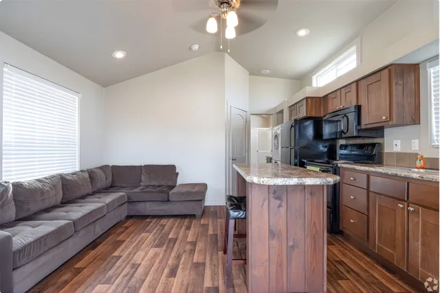 a living room with stainless steel appliances kitchen island granite countertop furniture and a kitchen view
