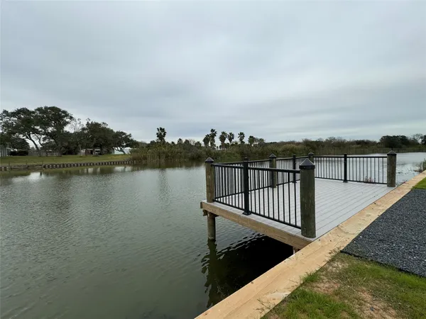 an outdoor sitting area with furniture and lake view