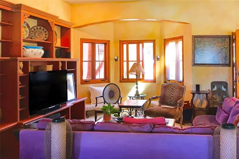 a living room with furniture a flat screen tv and a floor to ceiling window
