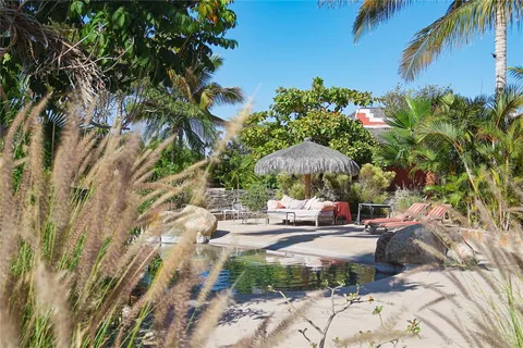 a backyard of a house with table and chairs under an umbrella