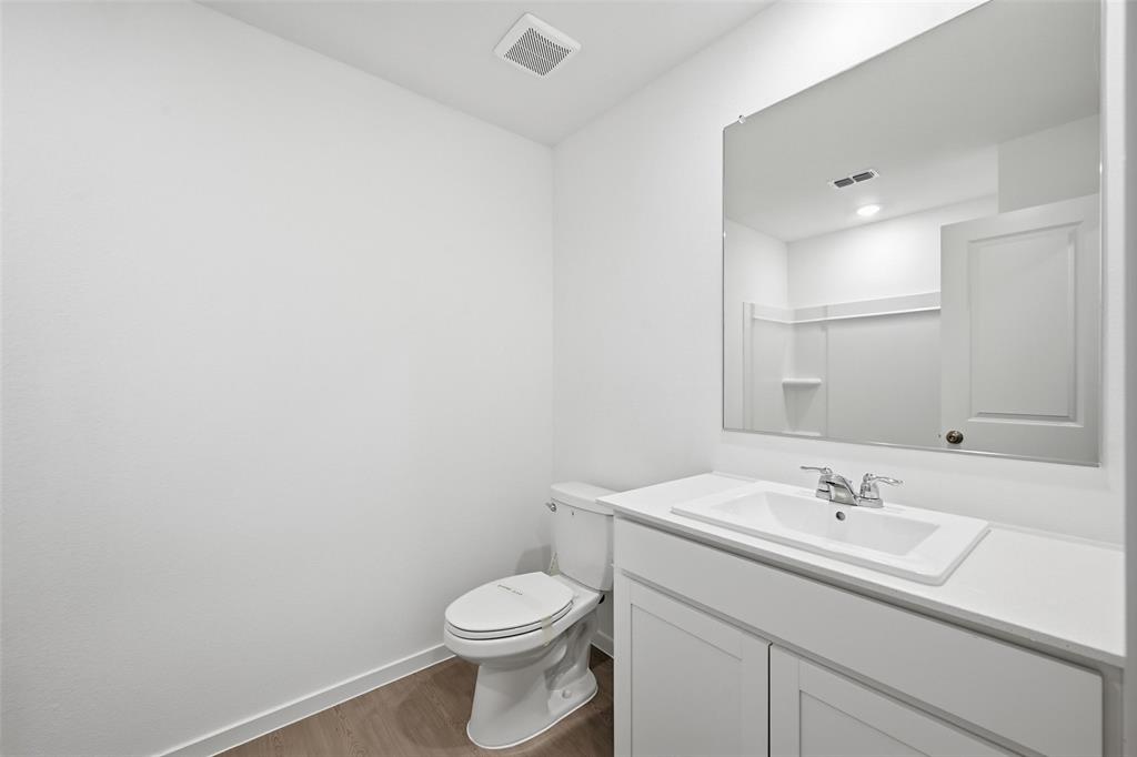 1037 Raintree Road Princeton, TX 75407 - Photo 16 of 21 a bathroom with a sink a toilet and mirror