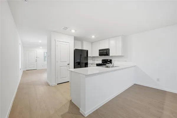 a view of kitchen with stainless steel appliances refrigerator sink and cabinets