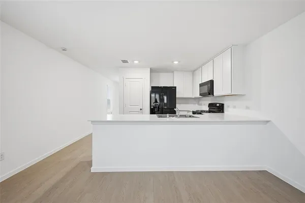 a view of kitchen with stainless steel appliances granite countertop refrigerator sink and stove