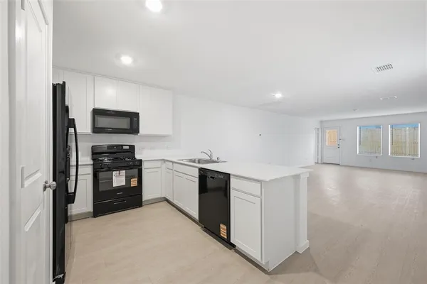 a kitchen with a stove top oven and refrigerator