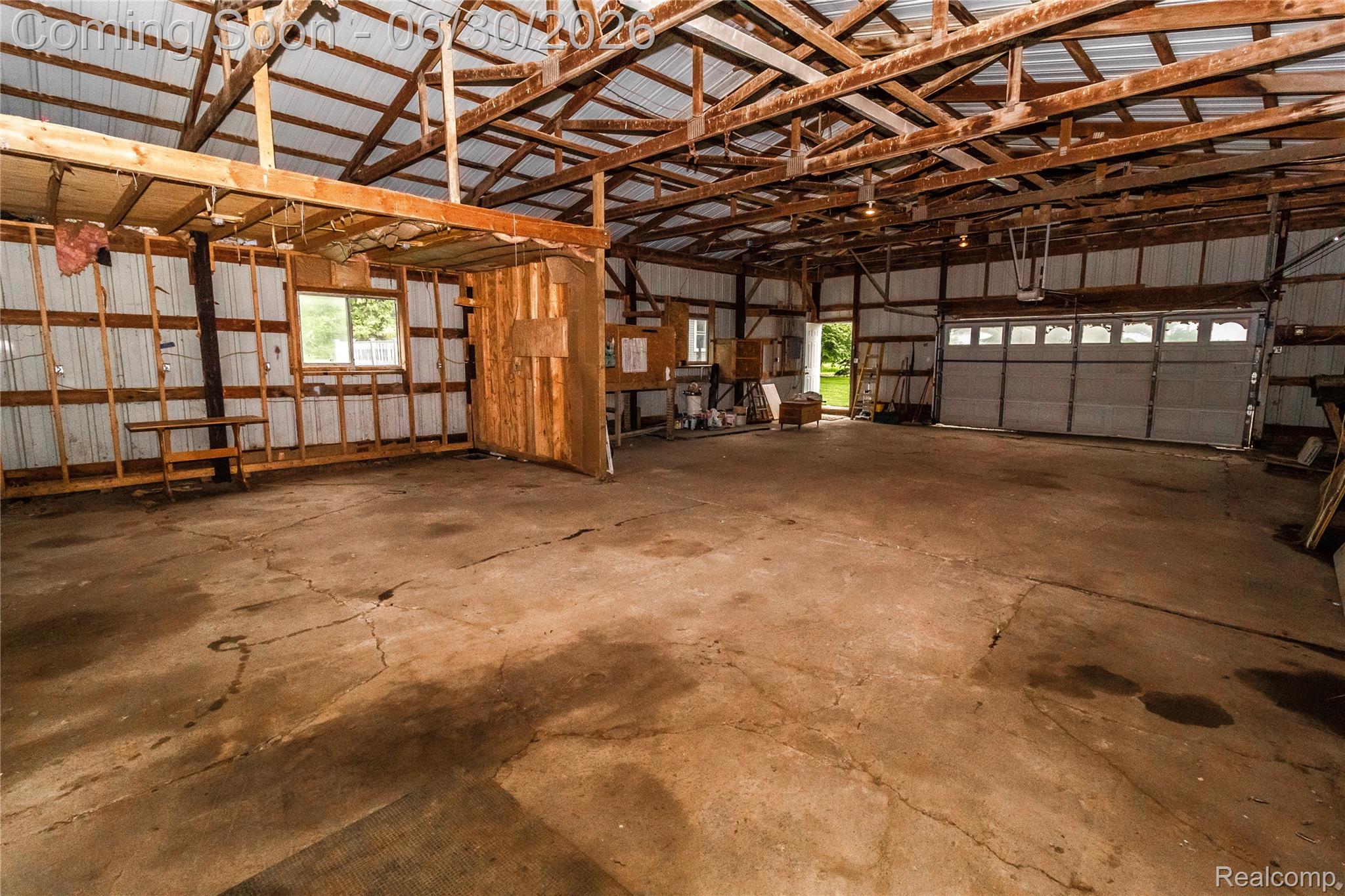 8150 Norman Road Imlay City, MI 48444 - Photo 55 of 58 Spacious interior featuring a concrete floor, exposed wooden beams, and a corrugated metal ceiling