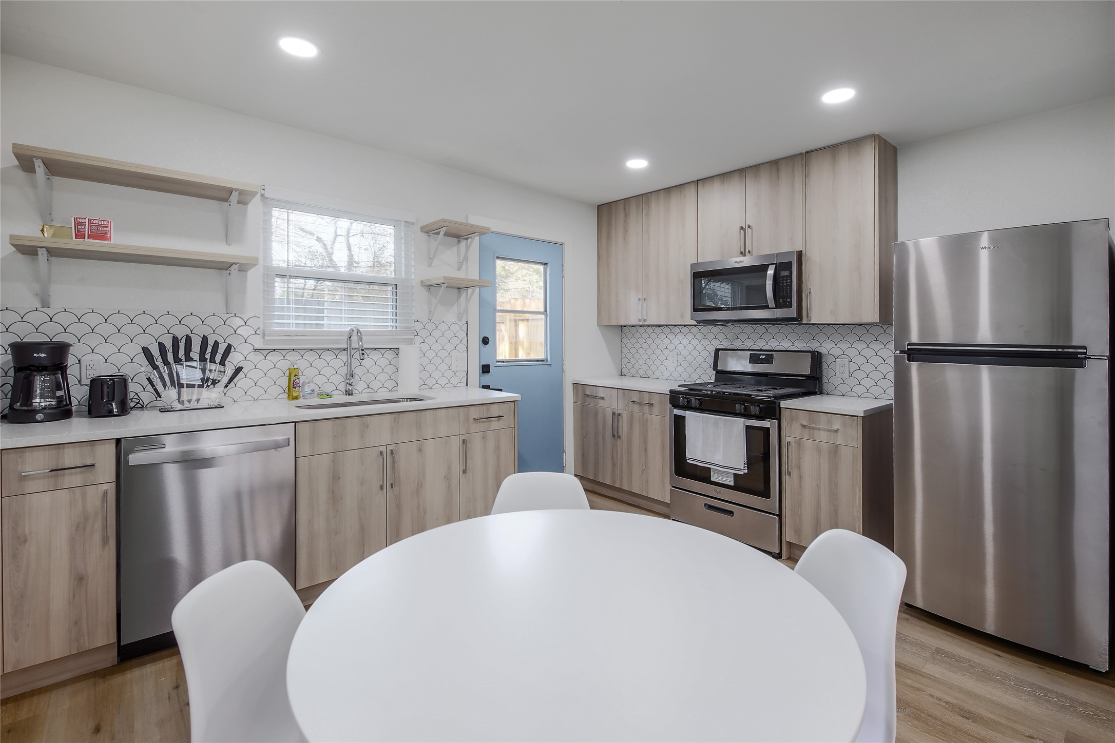 10509 Macmora Road, Unit A Austin, TX 78758 - Photo 5 of 17 A well-appointed kitchen features stainless steel appliances, a stylish tiled backsplash, and recessed lighting.
