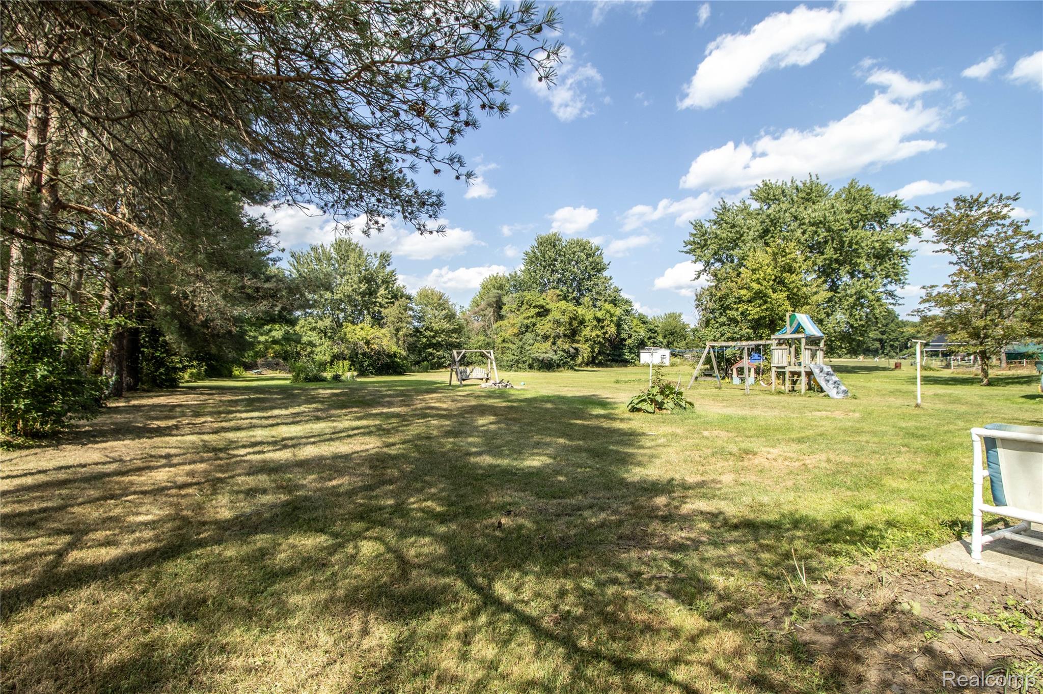 10340 Farrand Road Montrose, MI 48457 - Photo 9 of 33 Expansive grassy lawn with mature trees and a dedicated recreational structure