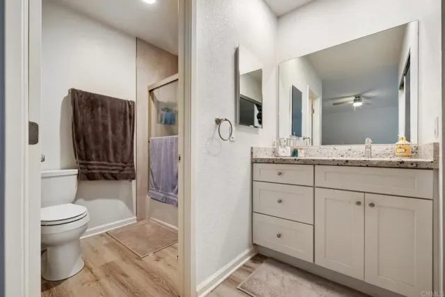 a bathroom with a granite countertop sink toilet and shower