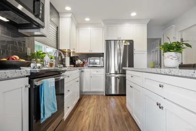 a kitchen with white cabinets and stainless steel appliances