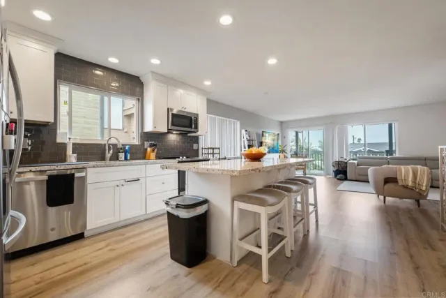 a kitchen with a sink stove cabinets and wooden floor