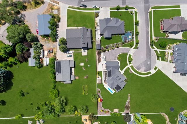 580 North 300 East Logan, UT 84321 - Photo 16 of 74 Aerial representation of a residential area featuring multiple properties with expansive green lawns and mature landscaping