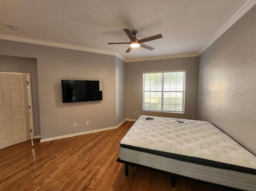 7511 Bayport Road, Unit 5 Orlando, FL 32819 - Photo 13 of 26 a bedroom with a bed and a flat screen tv