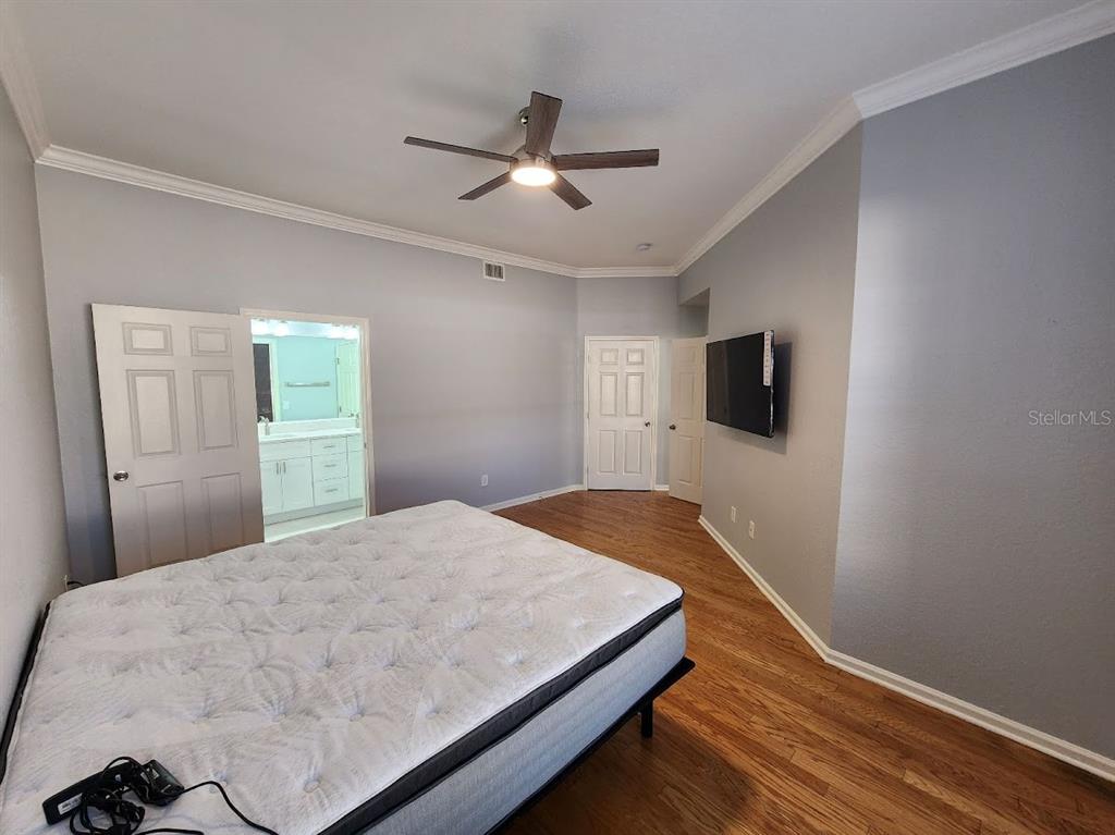 7511 Bayport Road, Unit 5 Orlando, FL 32819 - Photo 14 of 26 a bedroom with a bed and a flat screen tv
