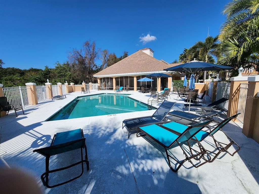 7511 Bayport Road, Unit 5 Orlando, FL 32819 - Photo 20 of 26 a view of a patio with couches table and chairs with wooden floor and fence