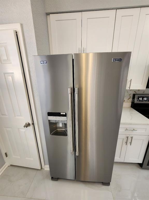 7511 Bayport Road, Unit 5 Orlando, FL 32819 - Photo 4 of 26 a kitchen with a refrigerator and a stove top oven