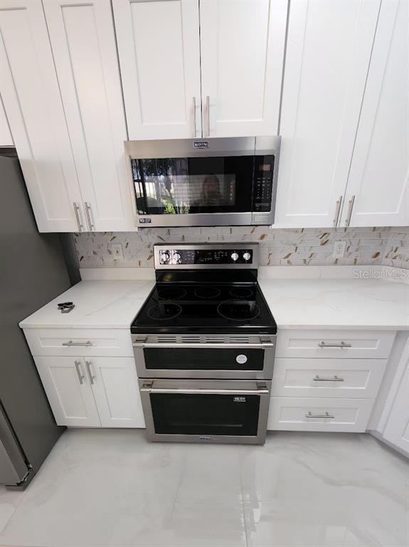 7511 Bayport Road, Unit 5 Orlando, FL 32819 - Photo 5 of 26 a stove top oven sitting inside of a kitchen