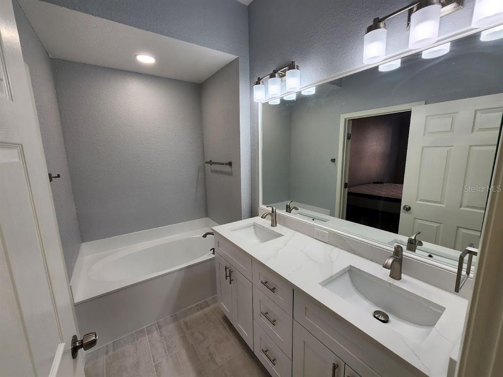 7511 Bayport Road, Unit 5 Orlando, FL 32819 - Photo 9 of 26 a bathroom with a tub sink and mirror
